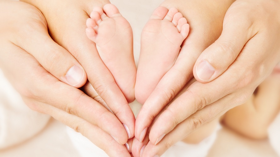 Newborn baby feet parents holding in hands Newborn baby feet parents holding in hands