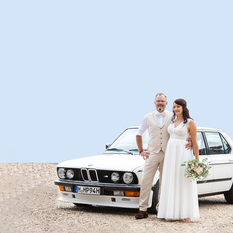 Hochzeitspaar vor BMW.
