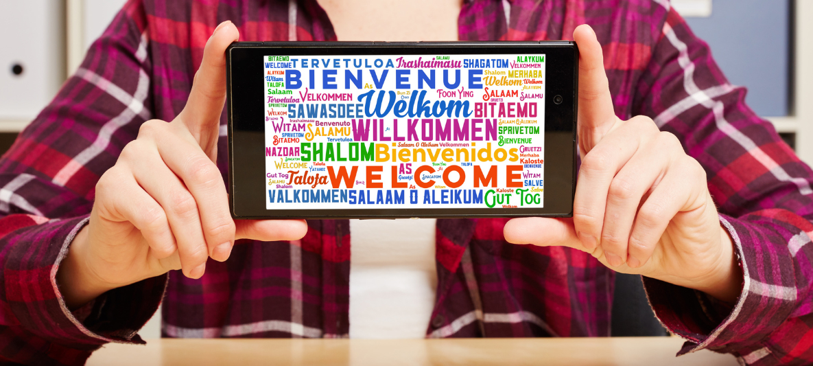 Smartphone showing 'Welcome' image A person shows a smartphone image that says 'Welcome' in different languages
