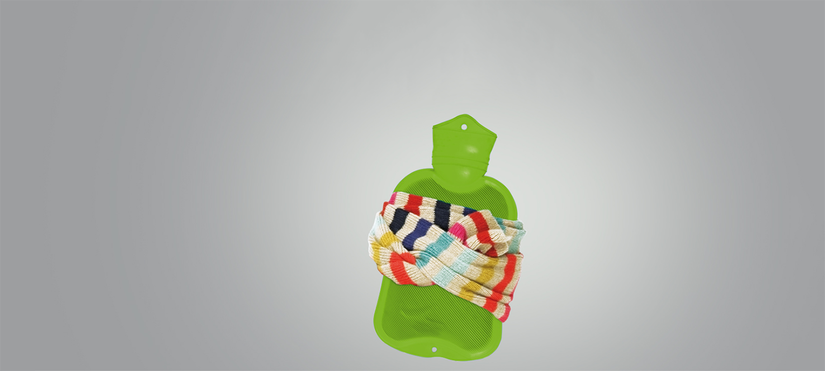 Gruene Waermflasche ist mit einem bunten Schal umwickelt Gruene Waermflasche ist mit einem bunten Schal umwickelt