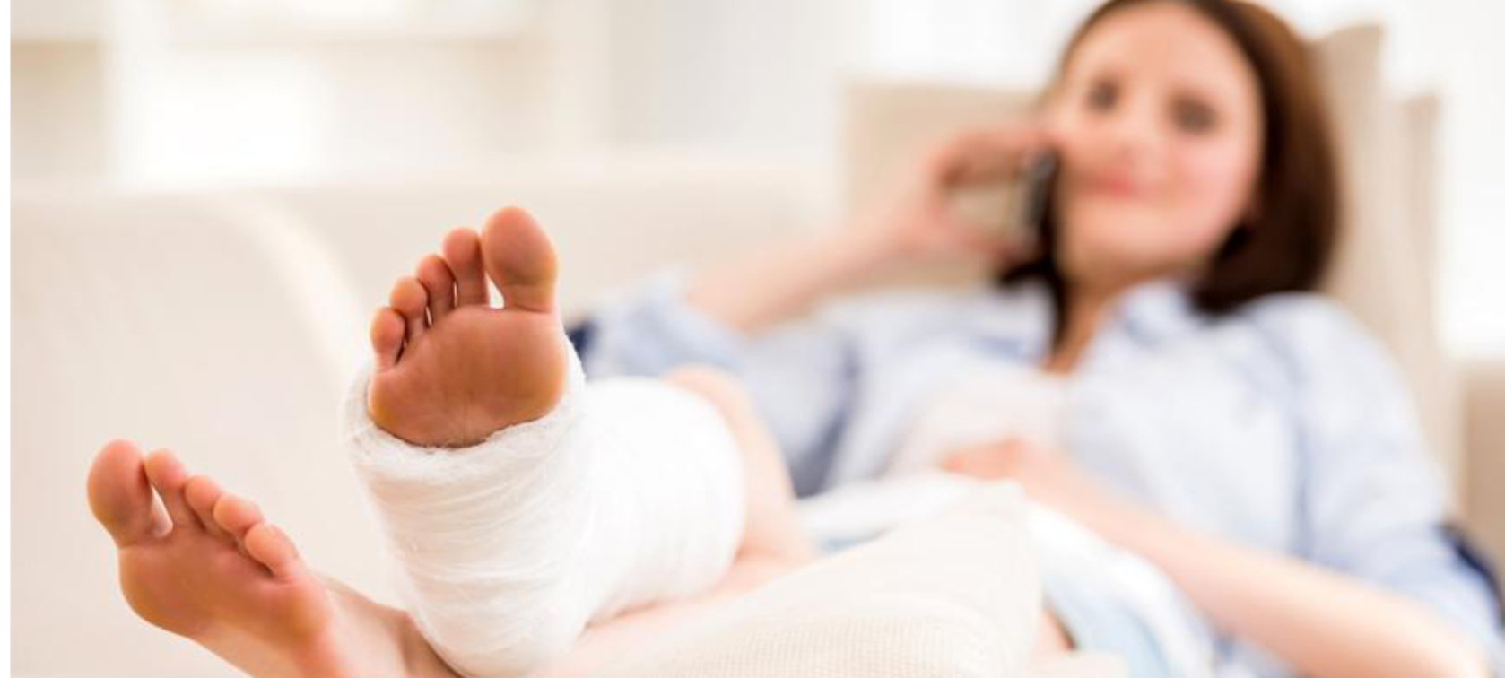 Patientin liegt mit Fußbandage im Krankenbett Patientin liegt mit Fußbandage im Krankenbett