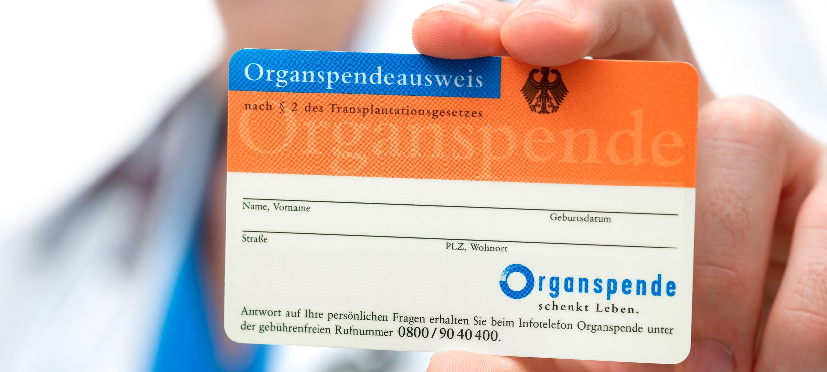 Arzt hält Organspendeausweis Arzt hält Organspendeausweis