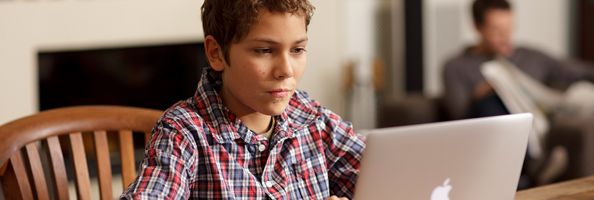 Junge sitzt am Tisch mit einem Laptop. Junge sitzt am Tisch mit einem Laptop.