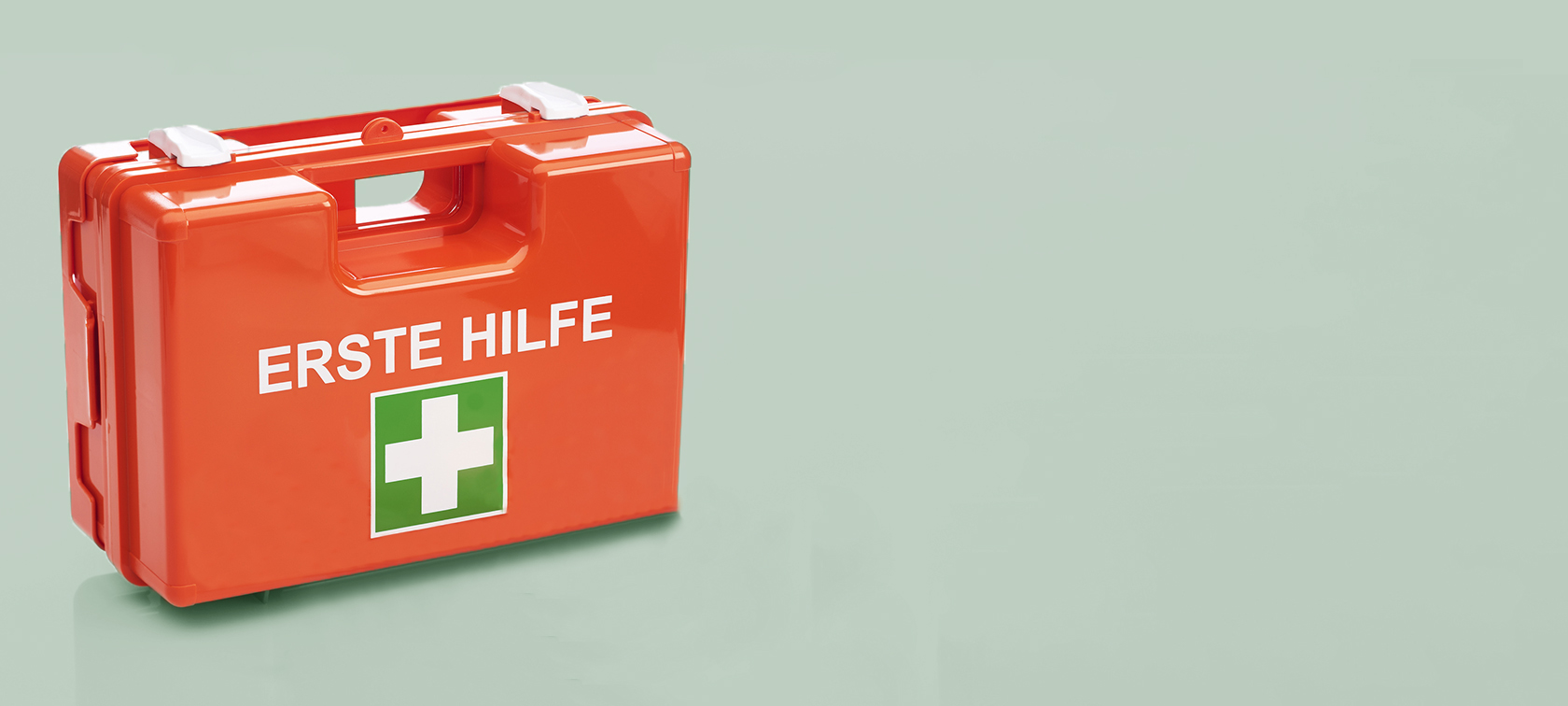 Erste Hilfe Kasten mit Pflaster und Verbandzeug davor Erste Hilfe Kasten mit Pflaster und Verbandzeug davor