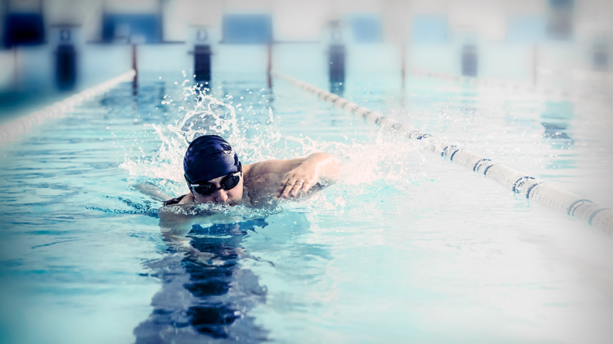 Mann schwimmt im Schwimmbecken